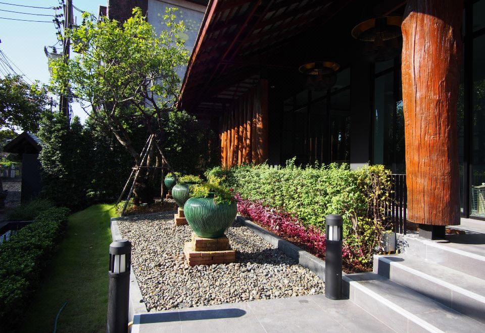 화분과 나무를 심은 건물 옆 정원 길
