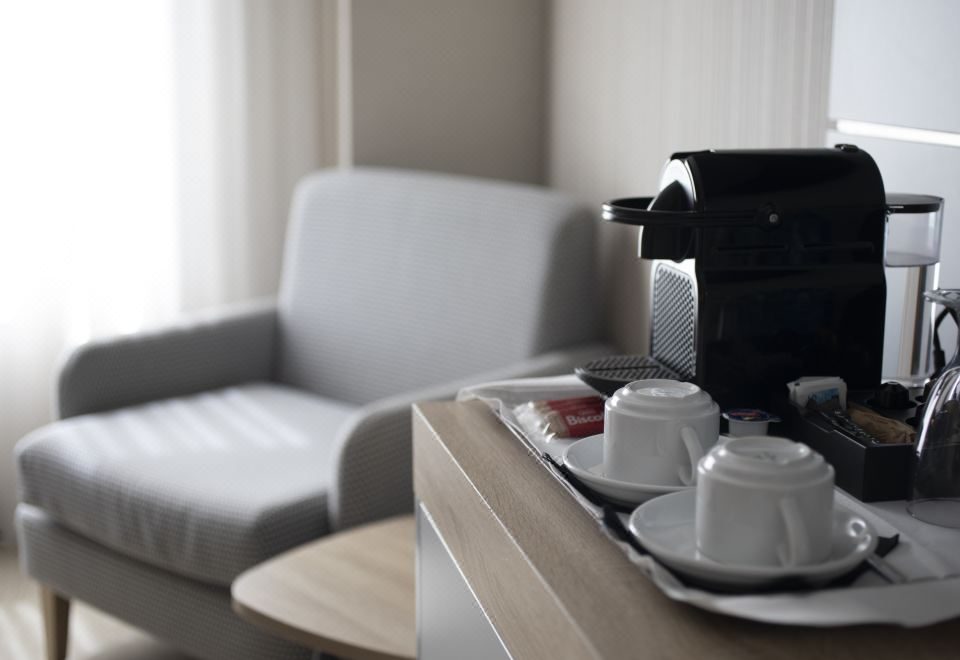 안락의자 옆 커피 머신과 찻잔 쟁반
